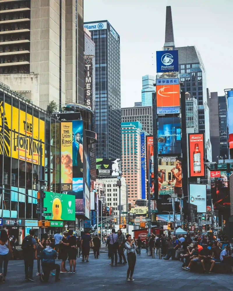 Large digital billboards in a busy city representing paid advertising and brand visibility.